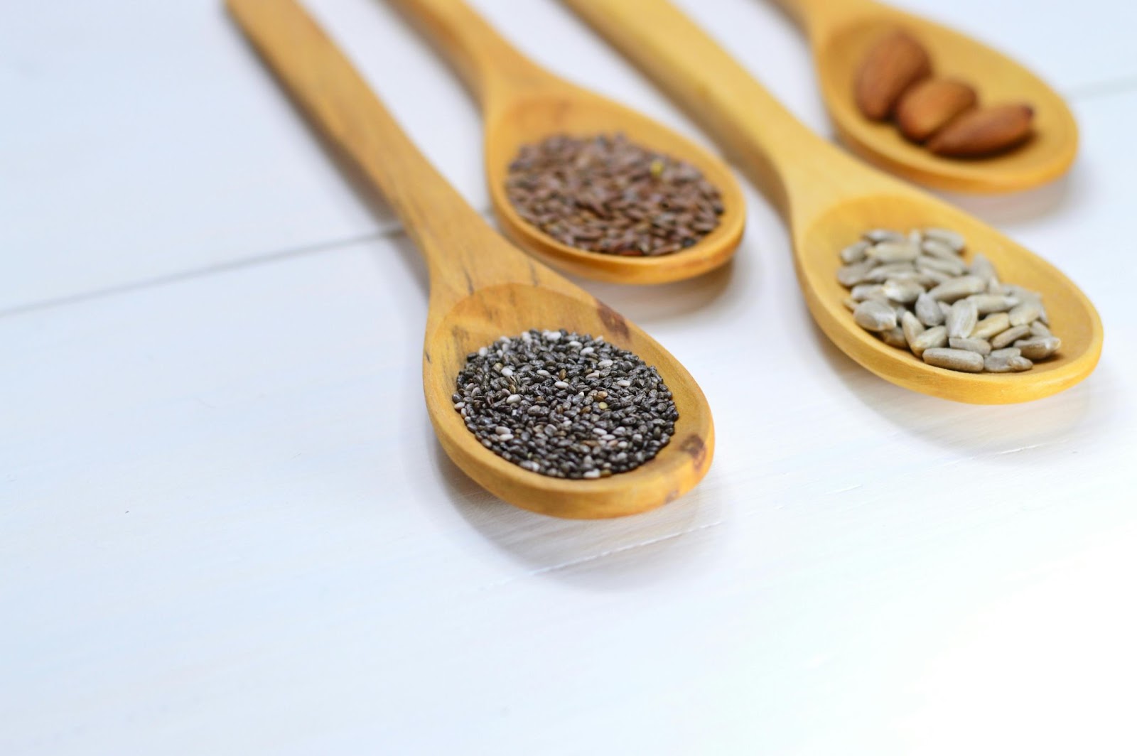 Wooden spoons holding various seeds. 