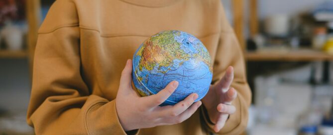 A child holding a blow-up model of earth.