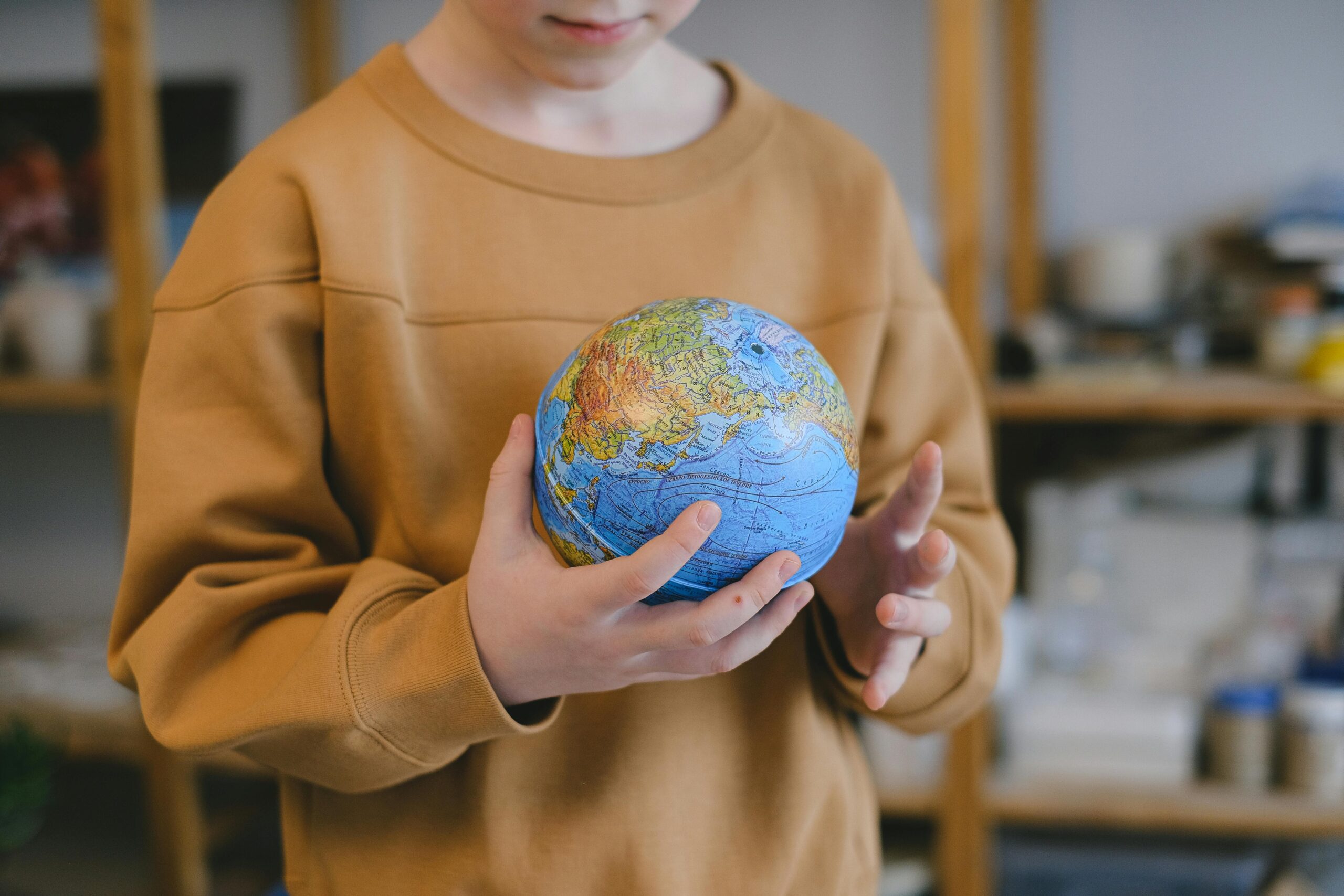 A child holding a blow-up model of earth.