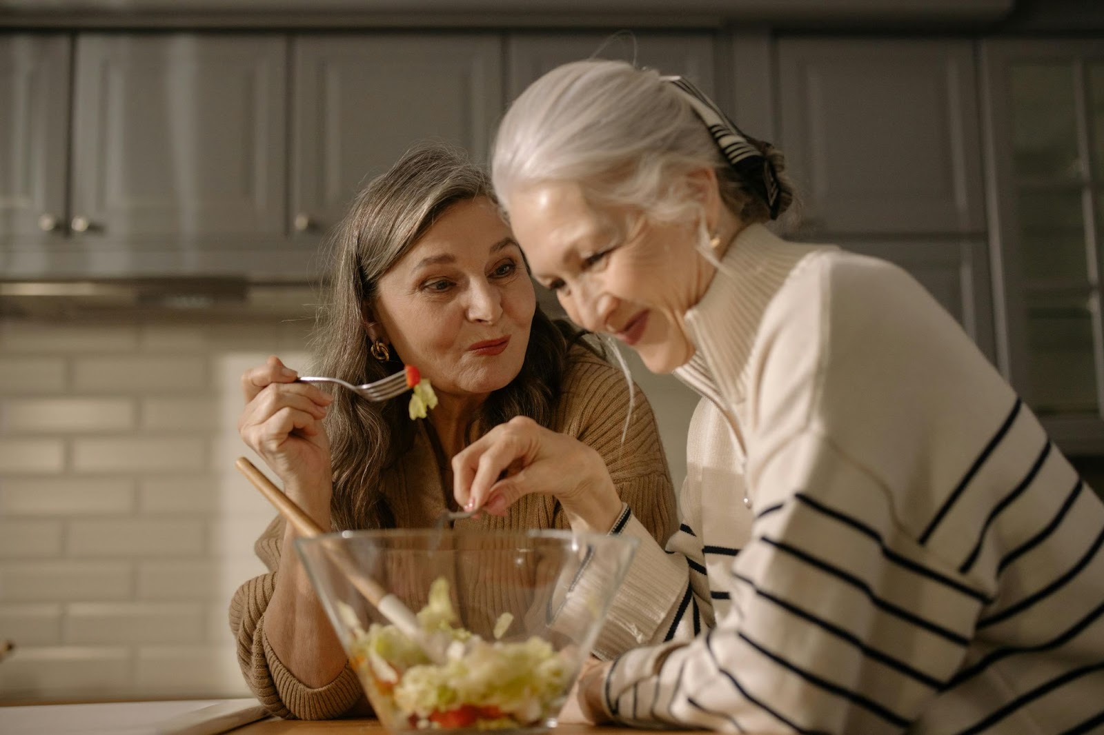 2 women sharing a salad.