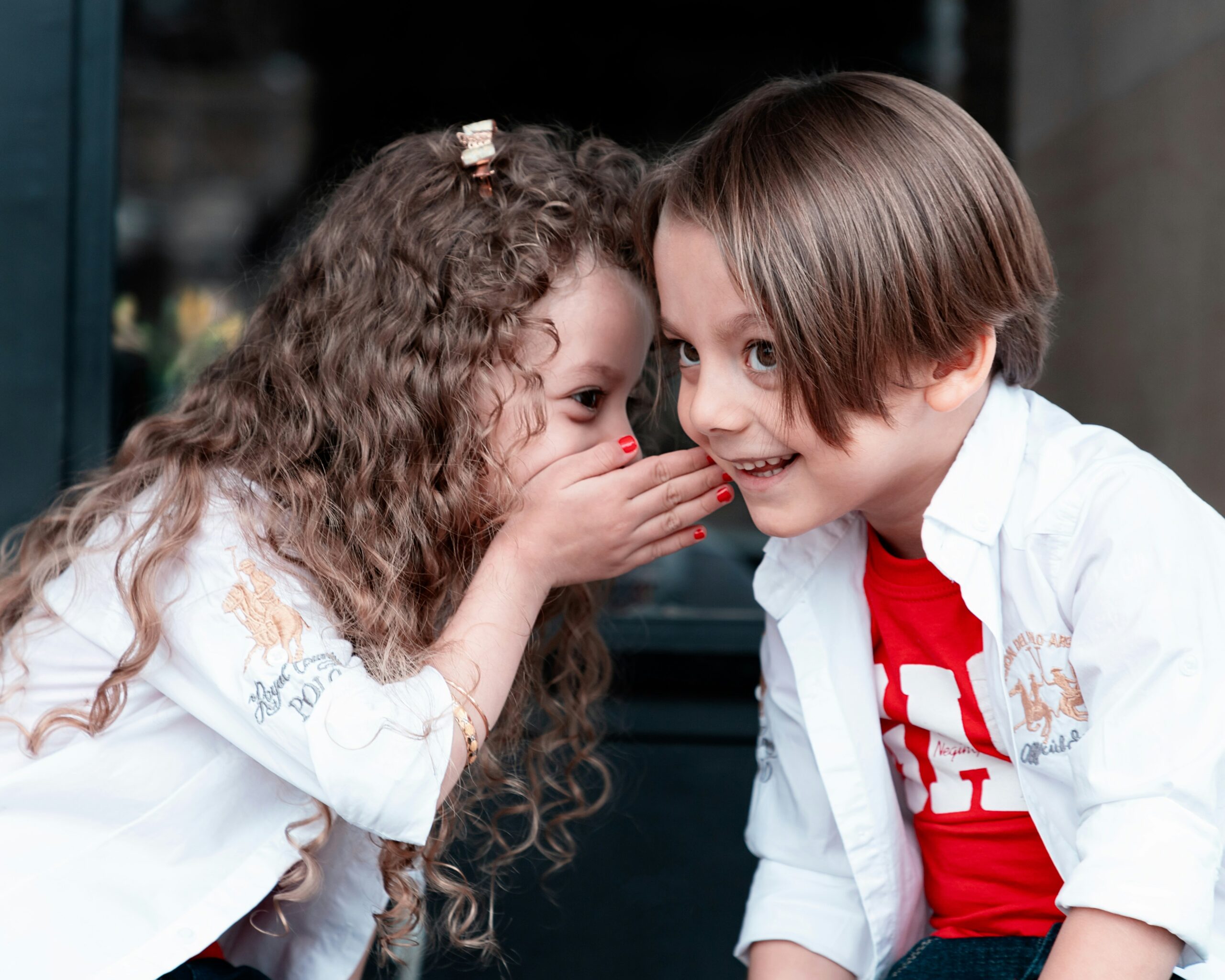 Children whispering to one another.